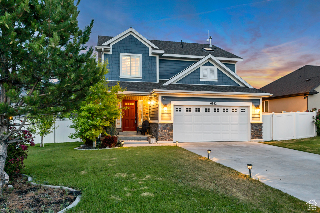 Craftsman-style house with concrete driveway, stone siding, and a shingled roof