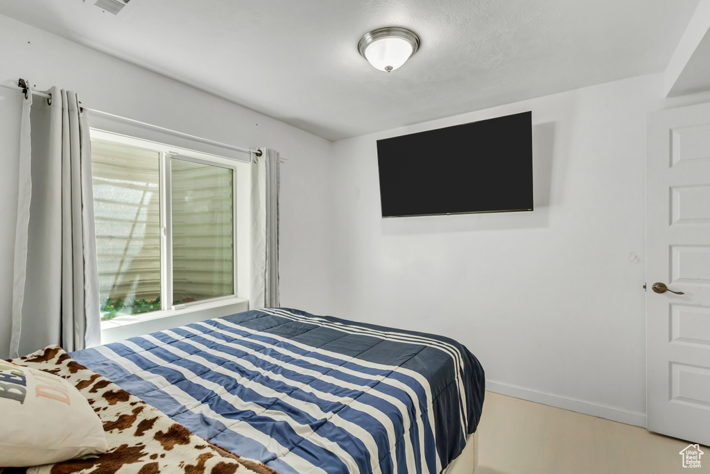 Bedroom with wood finished floors and baseboards