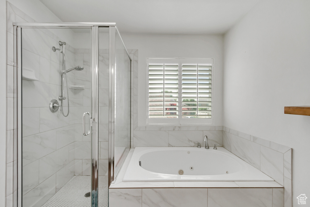 Full bath with a whirlpool tub and a stall shower