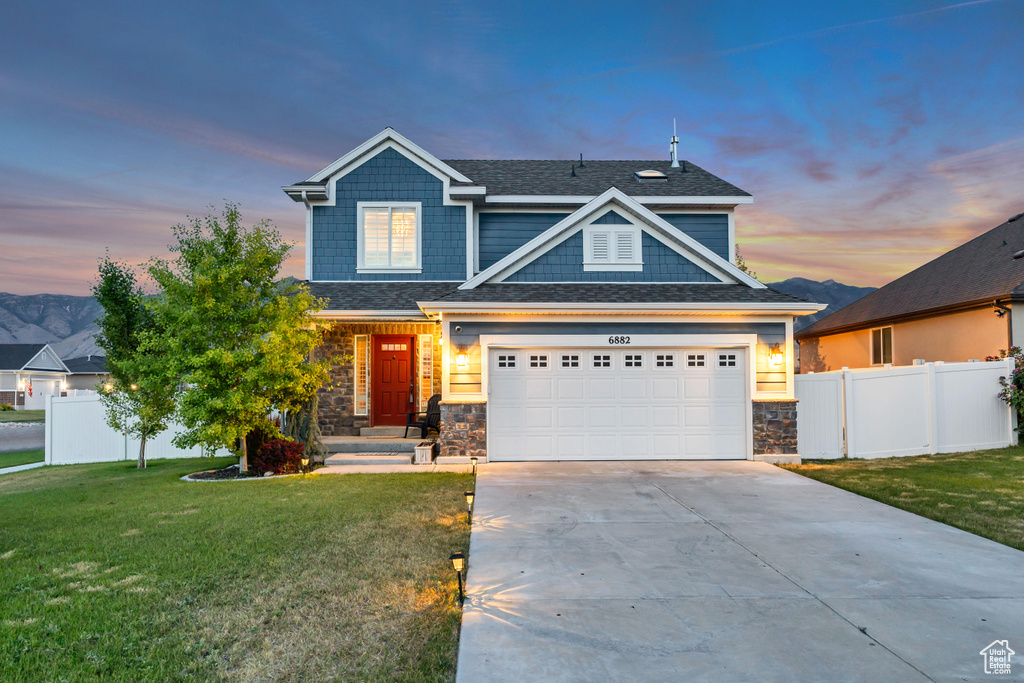 Craftsman house with driveway and stone siding