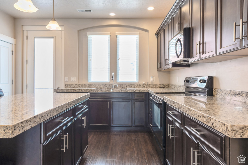 Kitchen featuring range with electric cooktop, stainless steel microwave, dark wood-type flooring, plenty of natural light, and recessed lighting