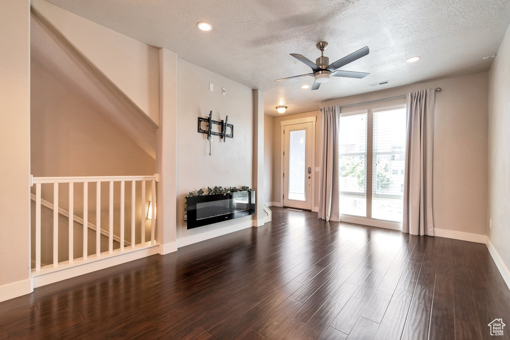 Unfurnished living room with a ceiling fan, wood finished floors, a textured ceiling, and recessed lighting