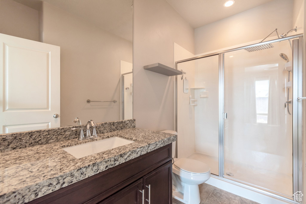 Bathroom with vanity, a stall shower, and tile patterned floors