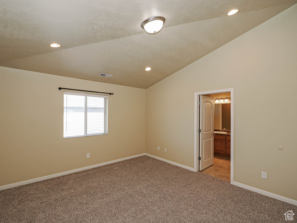 Spare room featuring light colored carpet, lofted ceiling, and recessed lighting