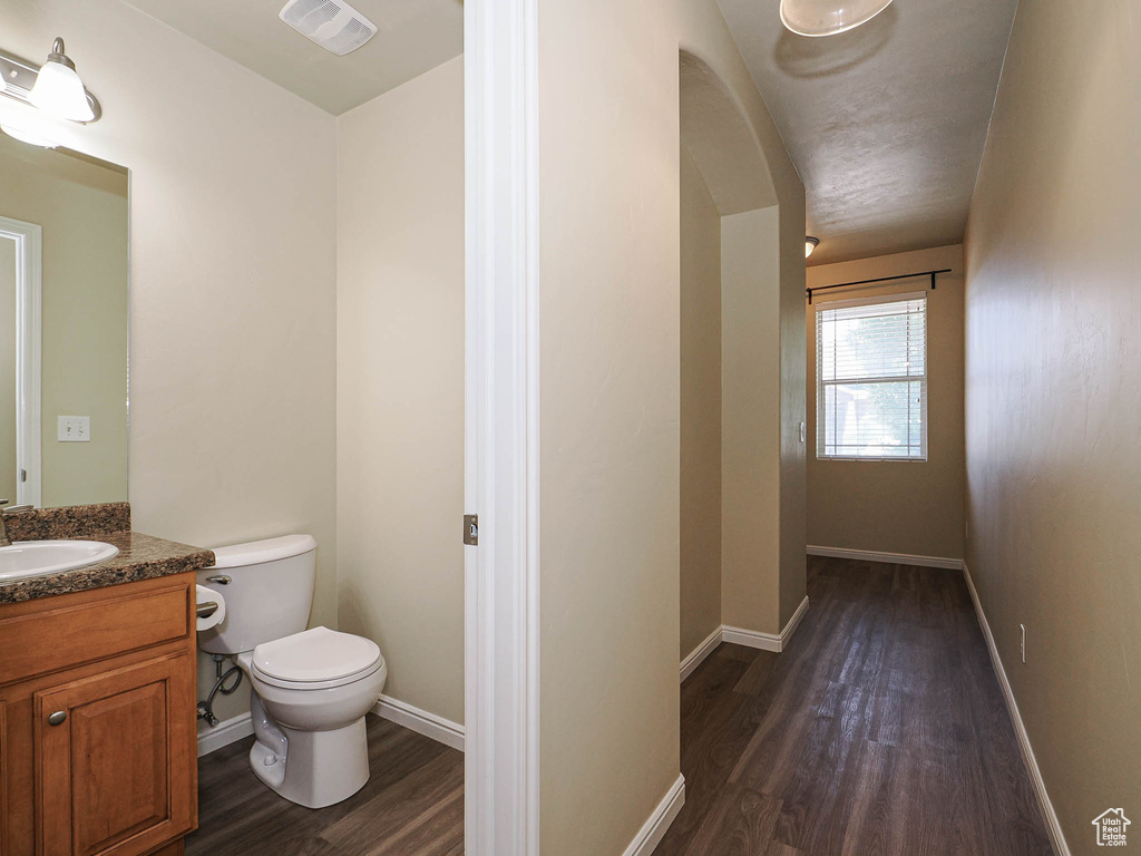Half bath featuring wood finished floors and vanity