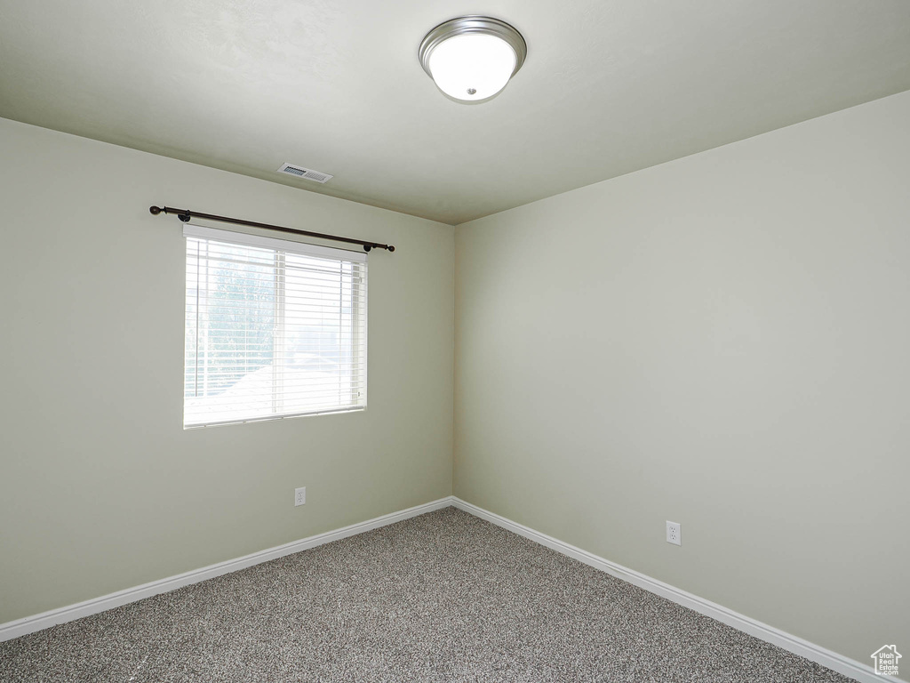 Carpeted empty room featuring baseboards
