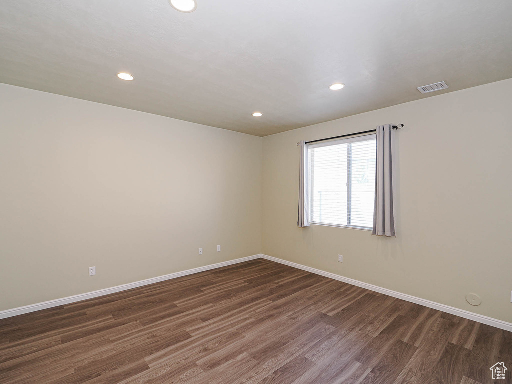 Spare room with wood finished floors and recessed lighting