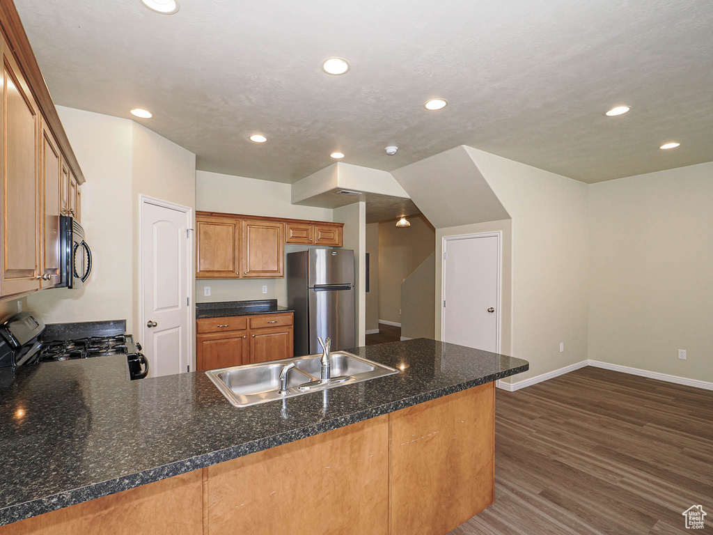 Kitchen with freestanding refrigerator, black range with gas stovetop, recessed lighting, a peninsula, and dark wood-style floors