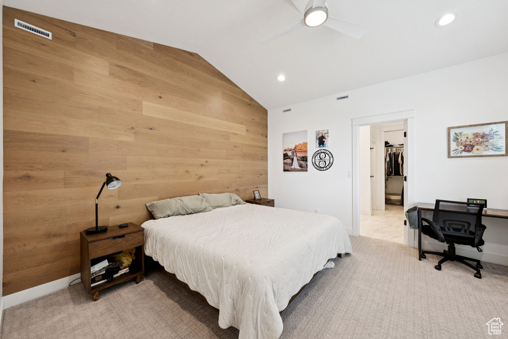 Bedroom with lofted ceiling, wooden walls, recessed lighting, light carpet, and ceiling fan