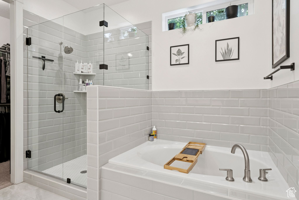 Bathroom featuring a garden tub, a shower stall, and a walk in closet