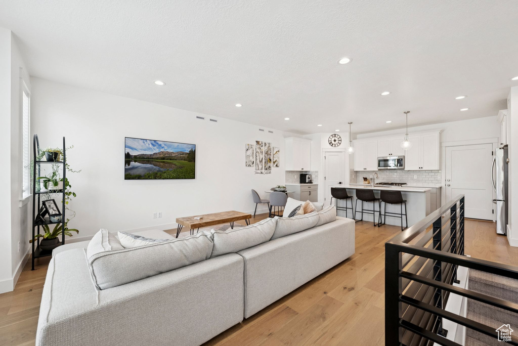 Living room with recessed lighting and light wood-style flooring