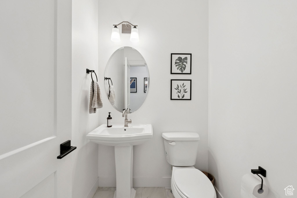 Half bathroom with baseboards and marble finish floors