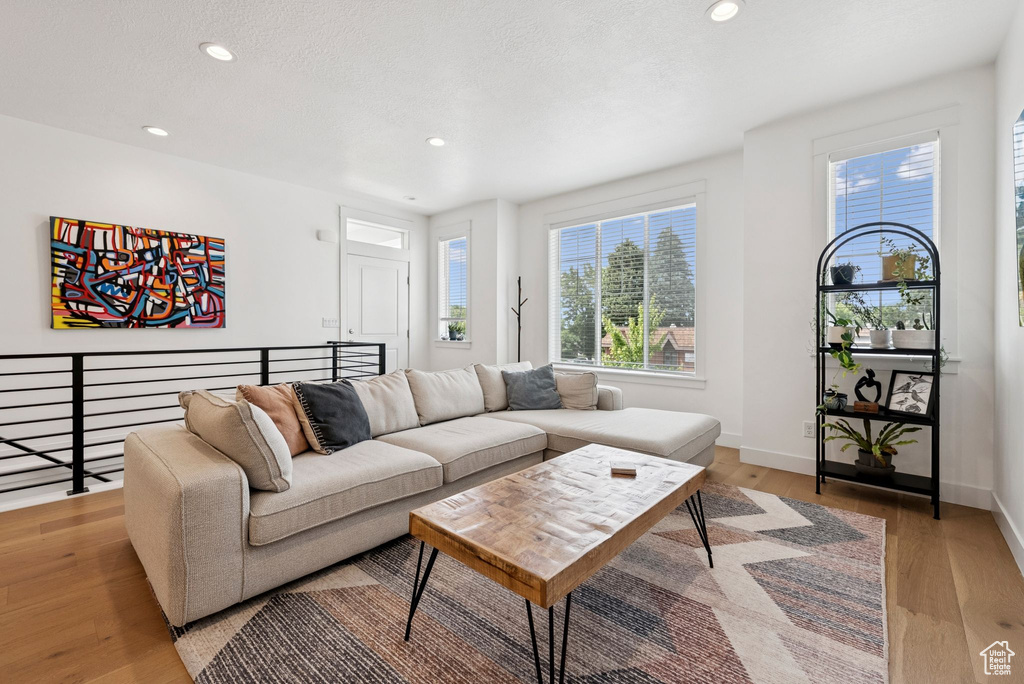 Living room with light wood-style floors and recessed lighting