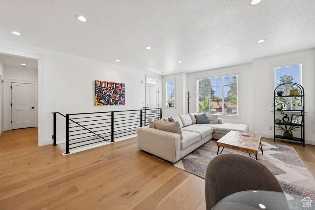 Living room with light wood-style floors and recessed lighting