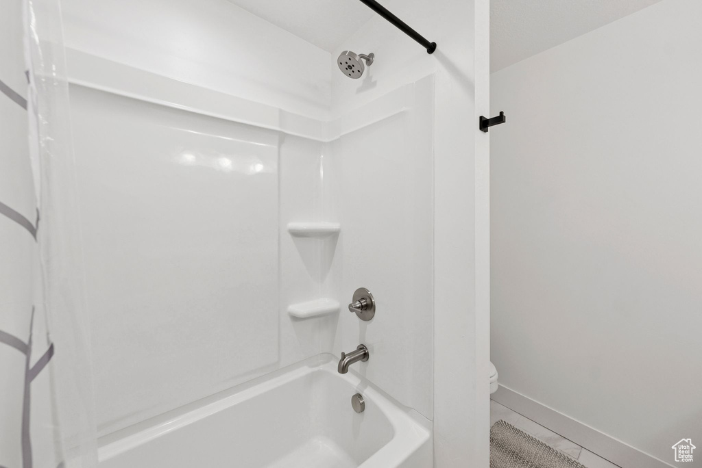 Full bath with washtub / shower combination and tile patterned flooring
