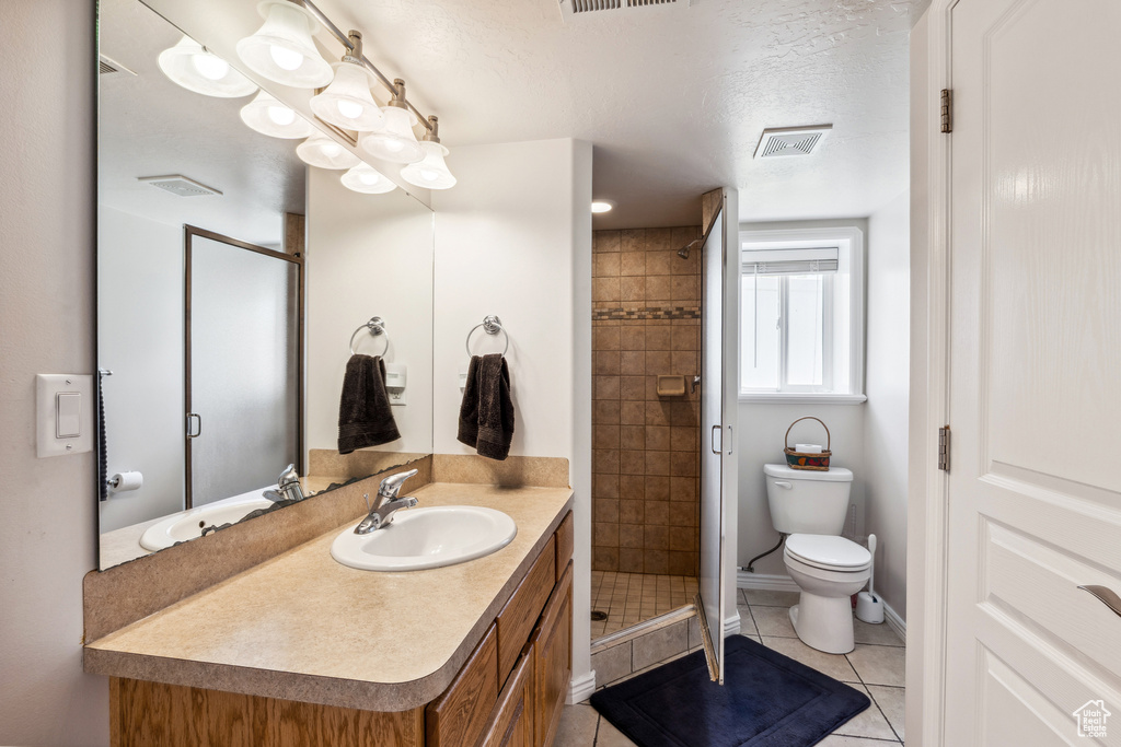 Bathroom with vanity, a shower stall, tile patterned floors, and a textured ceiling
