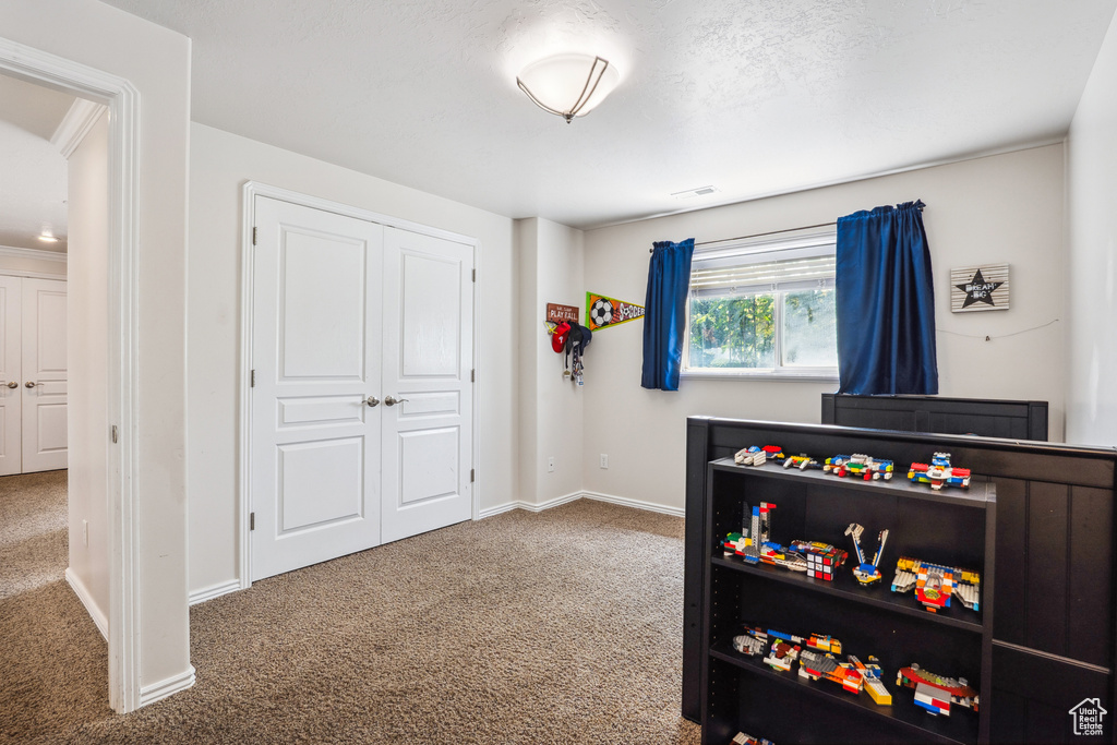 Carpeted bedroom with baseboards and a closet