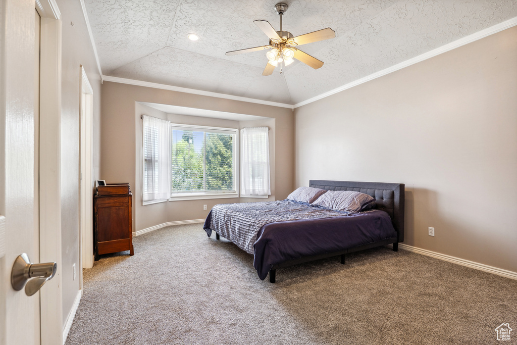 Bedroom with a textured ceiling, carpet flooring, vaulted ceiling, and a ceiling fan