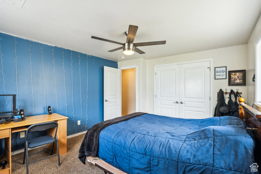 Bedroom featuring carpet floors, a ceiling fan, a desk, and a closet