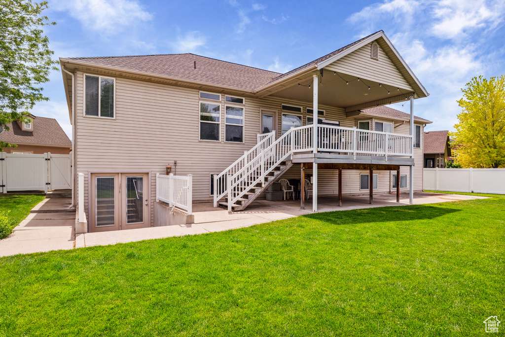 Back of property featuring a patio, a wooden deck, a gate, roof with shingles, and stairs