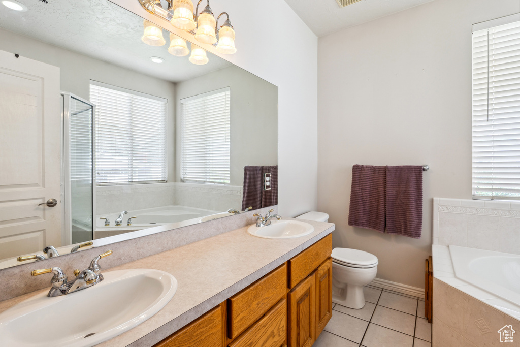Bathroom featuring plenty of natural light, a garden tub, a shower stall, and tile patterned flooring