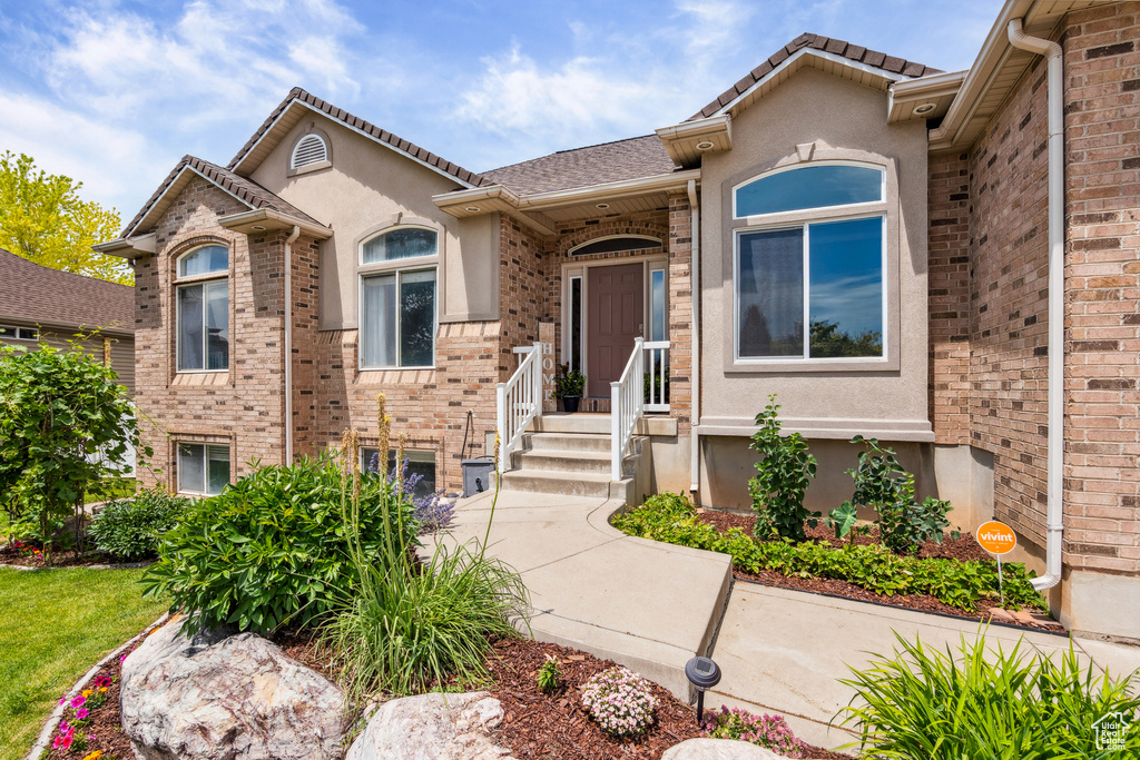 View of front of house featuring stucco siding and brick siding