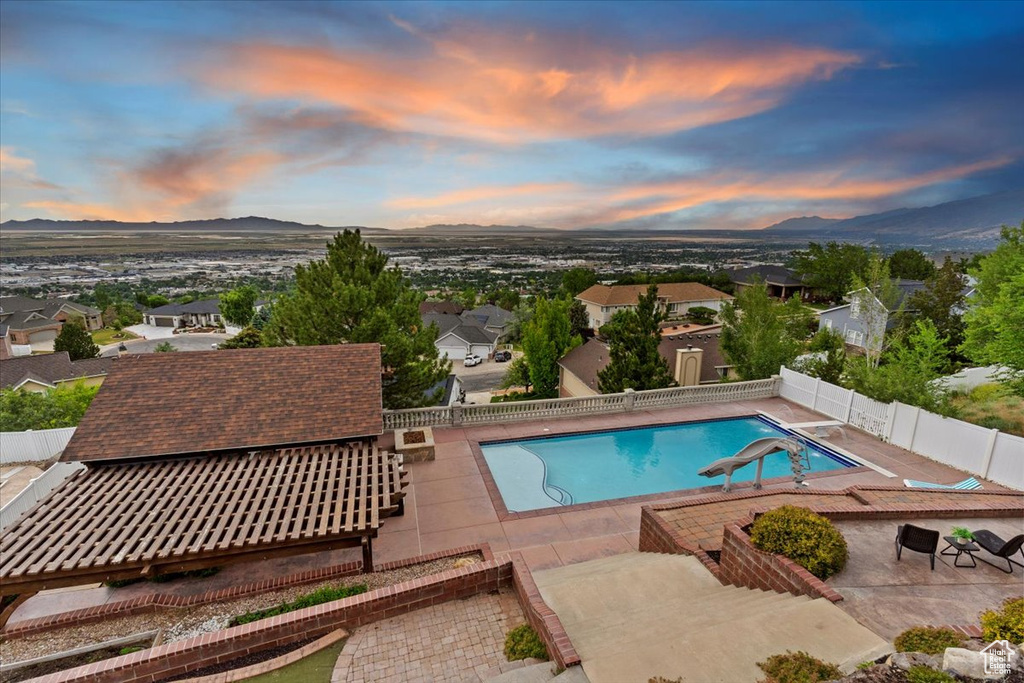 View of swimming pool with a fenced backyard, a mountain view, a patio area, and a residential view