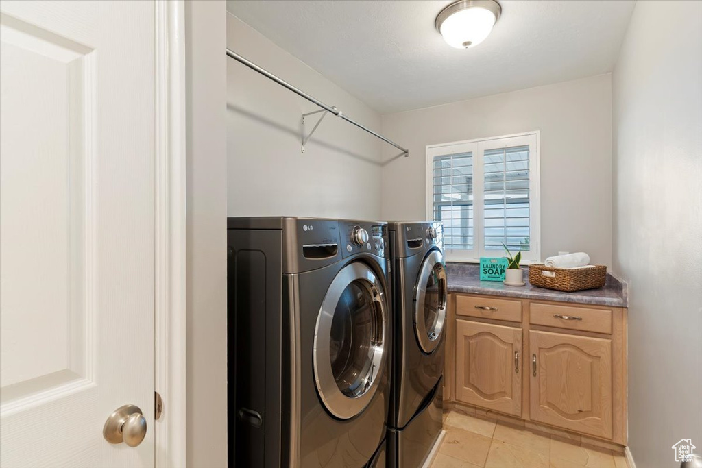 Washroom with washer and dryer and light tile patterned flooring