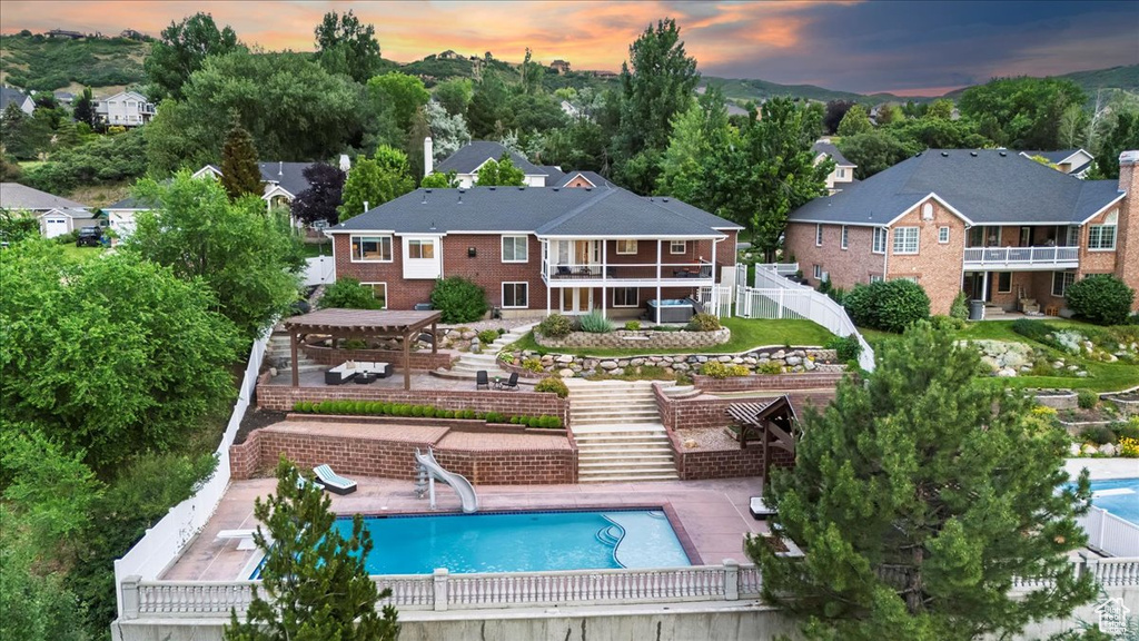 Back of property with stairway, a pergola, and a patio area