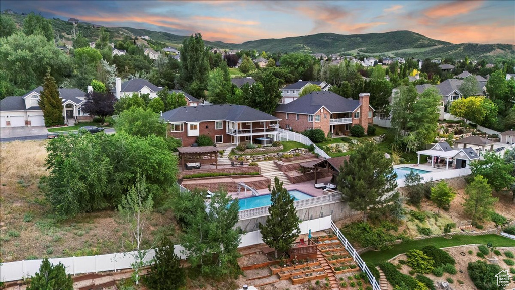 Aerial perspective of suburban area featuring a pool and mountains