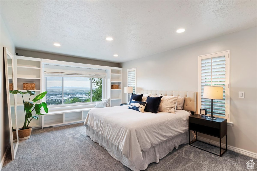 Carpeted bedroom with recessed lighting and a textured ceiling