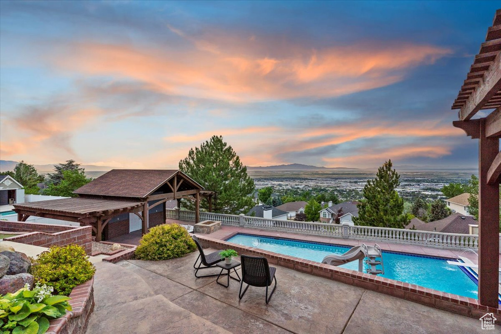 View of pool with a gazebo, a fenced backyard, a patio area, and a water slide