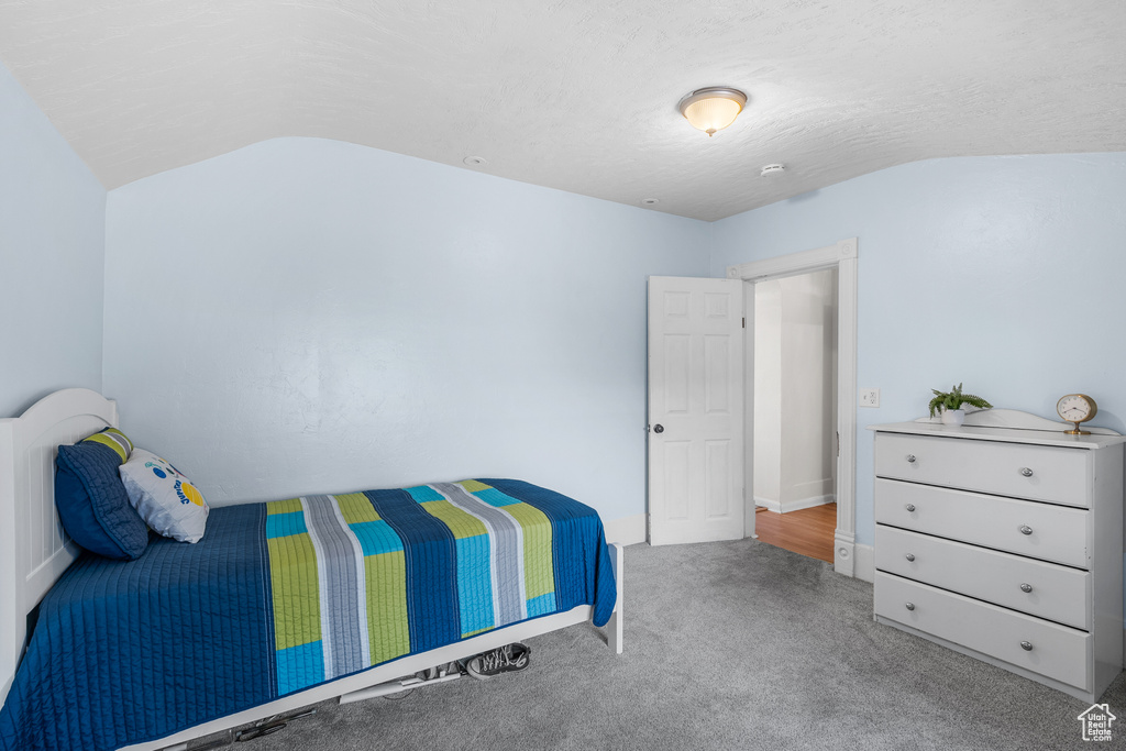 Carpeted bedroom featuring lofted ceiling