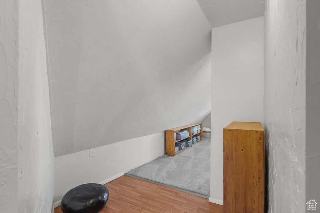 Additional living space with wood finished floors and vaulted ceiling