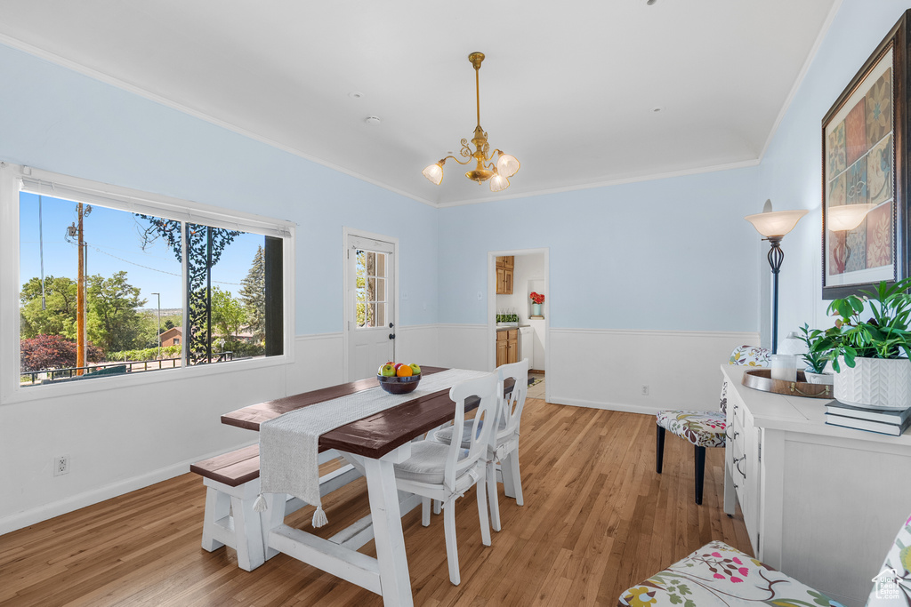 Dining room with a chandelier, light wood finished floors, and ornamental molding