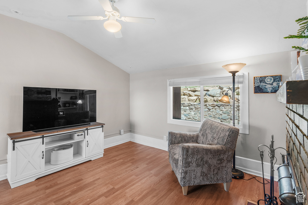 Sitting room with vaulted ceiling, light wood finished floors, and ceiling fan