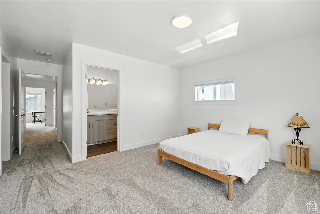 Bedroom with carpet, radiator, connected bathroom, and attic access