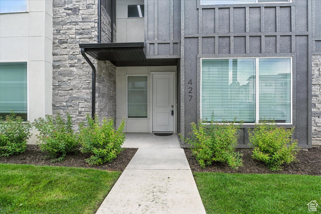 Entrance to property with stone siding and board and batten siding