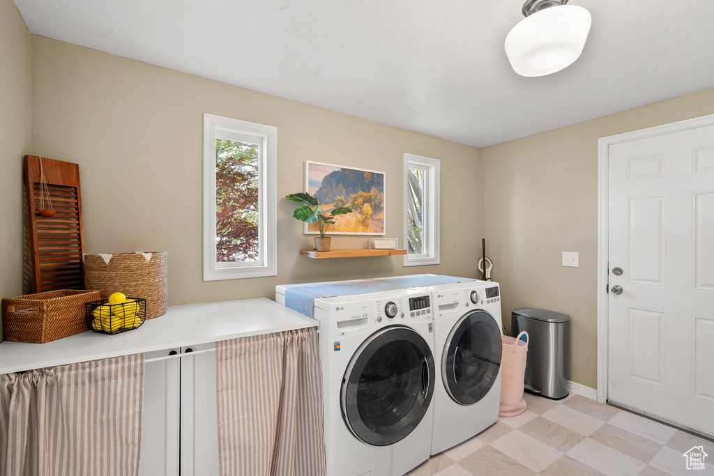 Washroom with washing machine and dryer and light floors