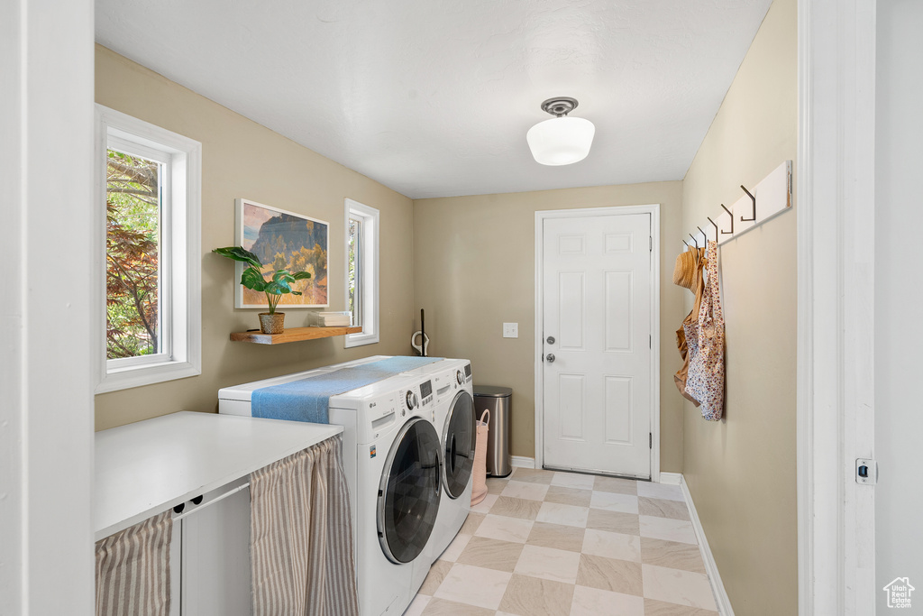 Washroom with washer and dryer and light floors