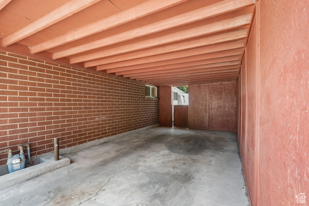 View of patio featuring an attached carport and a wall unit AC