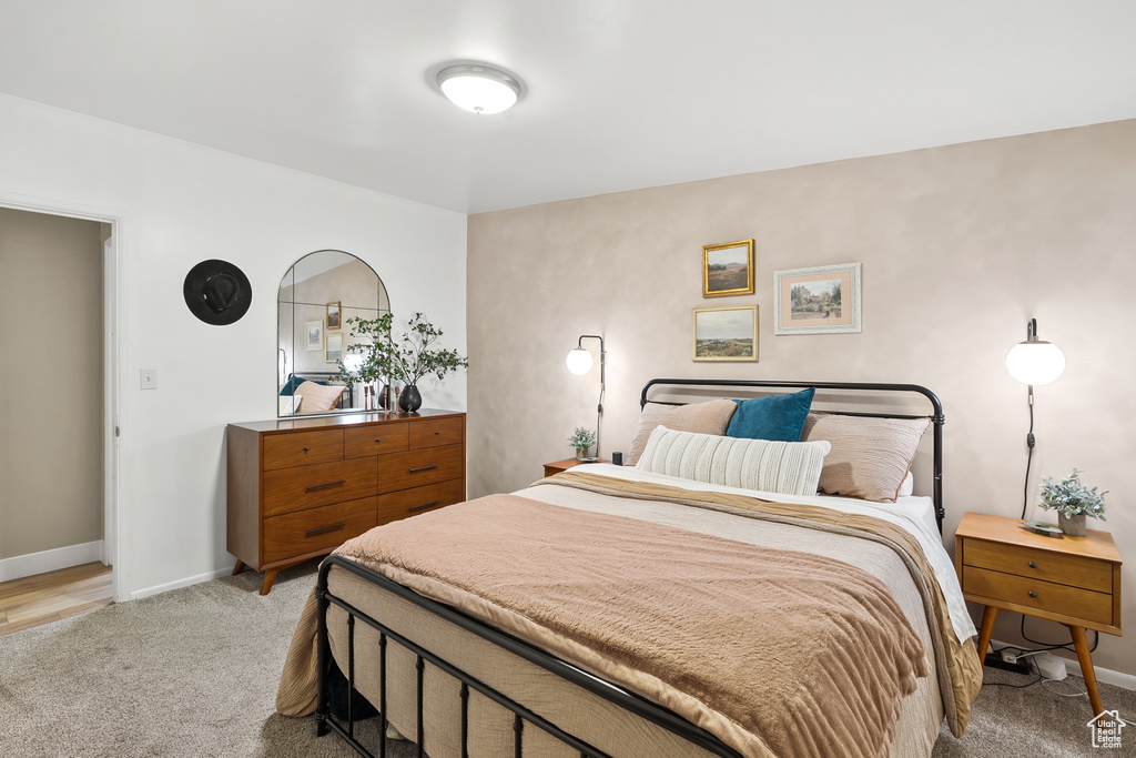Bedroom with light colored carpet and baseboards