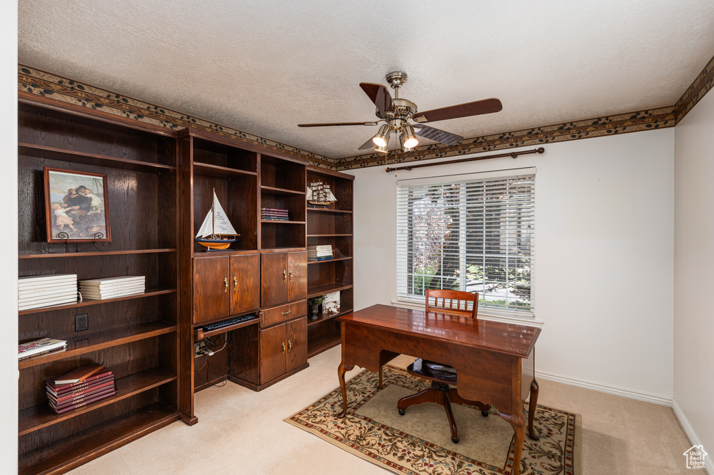 Office featuring light colored carpet, ceiling fan, and a textured ceiling