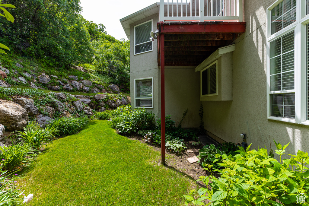 View of grassy yard with a balcony