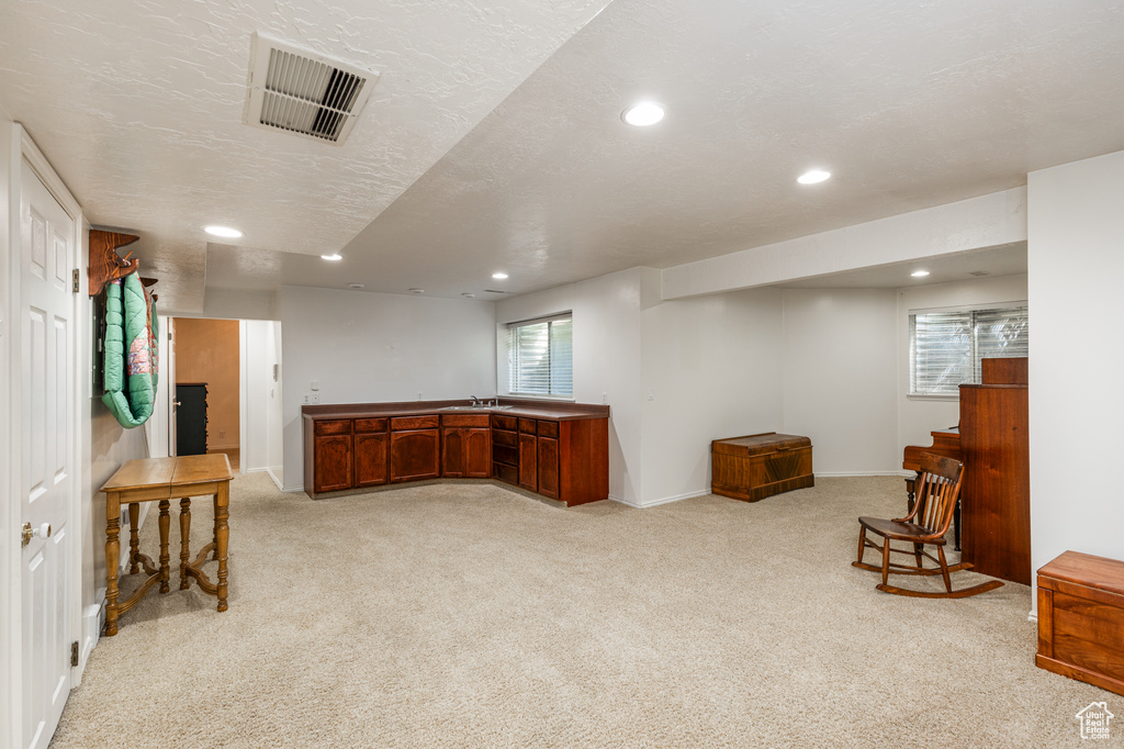 Living area featuring recessed lighting, light carpet, and bar