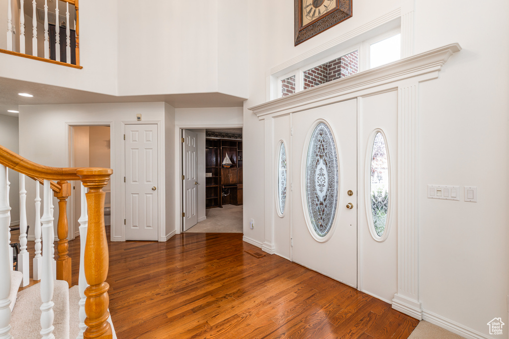 Entrance foyer with a high ceiling, wood finished floors, and stairway