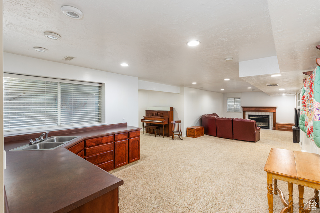 Living room featuring light carpet, a tile fireplace, and recessed lighting