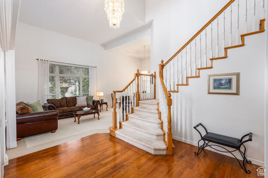 Foyer entrance featuring a chandelier, stairs, and wood finished floors