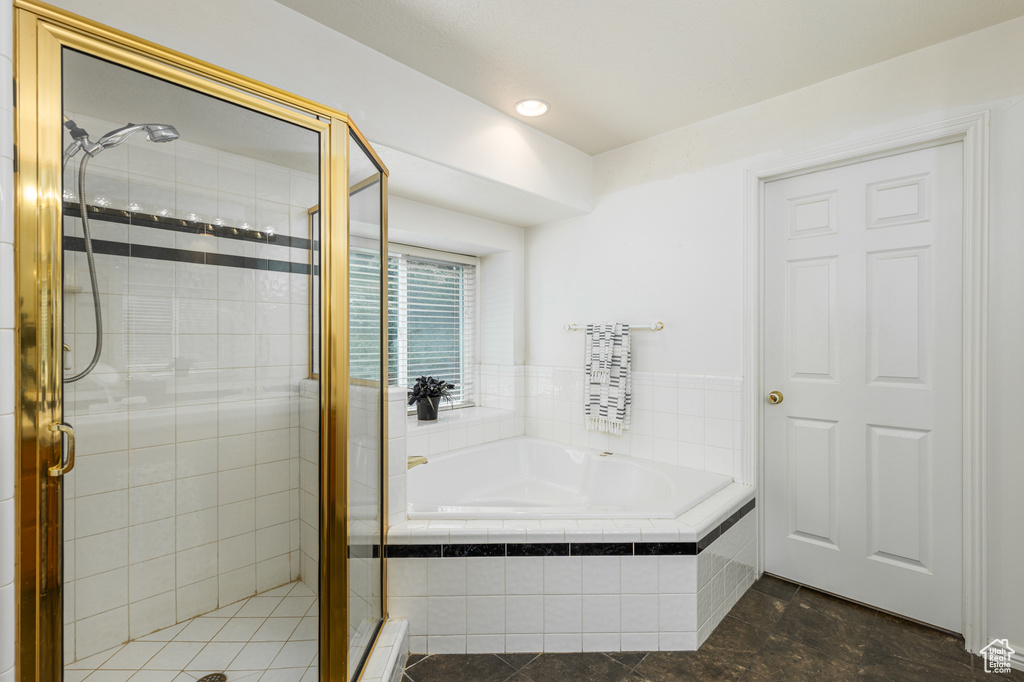 Full bathroom featuring a garden tub, a stall shower, and tile patterned floors