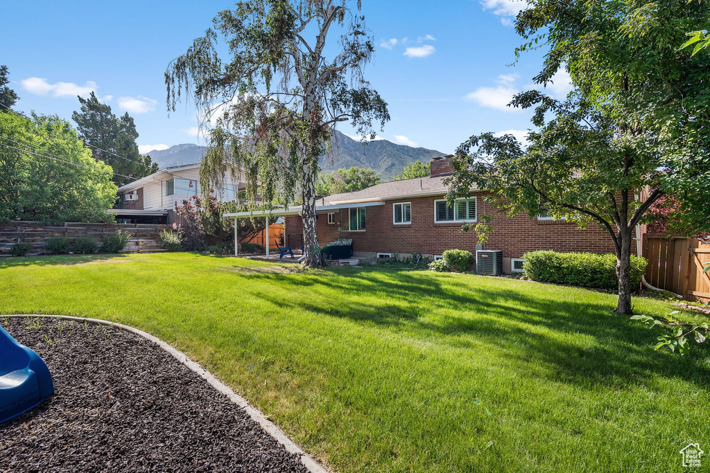 Fenced backyard featuring a mountain view